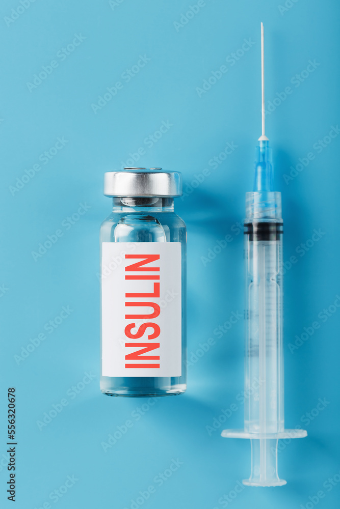 A bottle of insulin hormone and a syringe on the table A bottle of insulin hormone and a syringe on the table