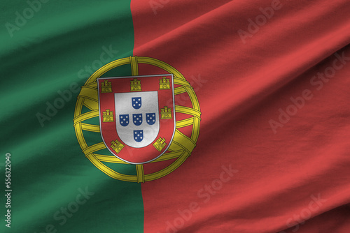 Portugal flag with big folds waving close up under the studio light indoors. The official symbols and colors in fabric banner photo