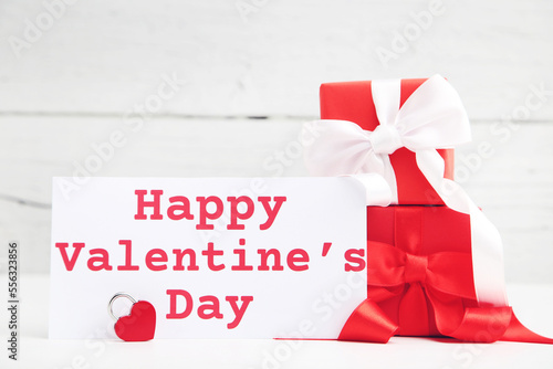 Gifts boxes and text Happy Valentines Day on wooden background