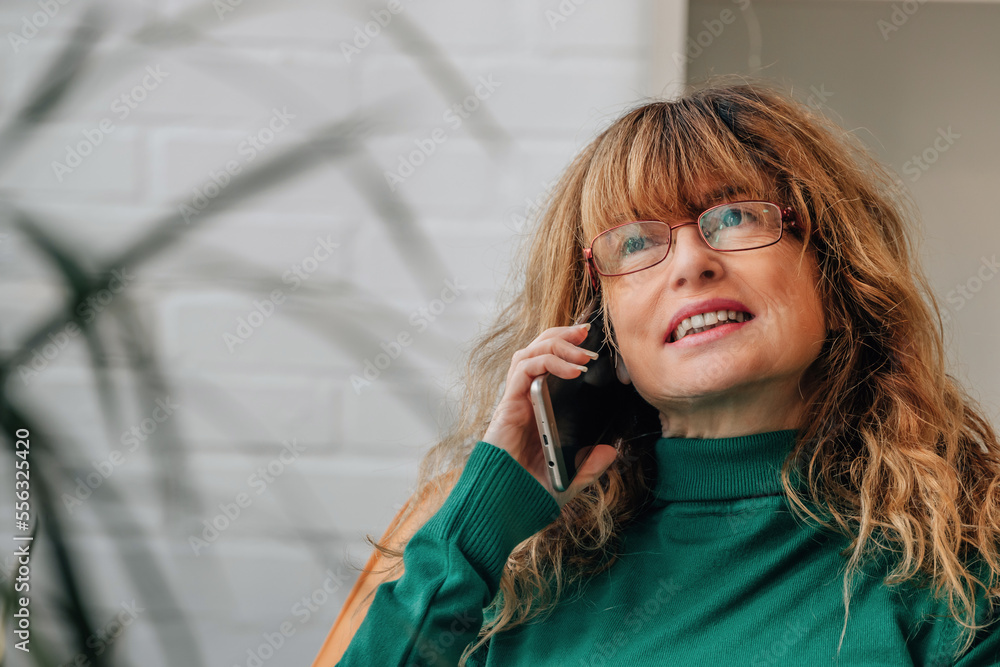Fototapeta premium middle-aged adult woman talking on mobile phone