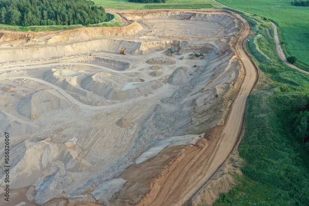 Minsk region, Belarus - August 14, 2022: Huge quarry in which sand is mined. Mining excavators extract sand. Sand mining. Career giant machines. Serpentine in a career.