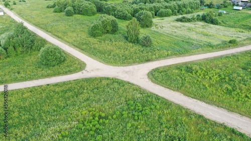 Rural crossroads. Crossroads of four roads. Gravel road. Crossroads in the village. Unpaved road.