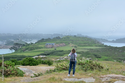 Une femme qui prend des photos depuis les hauteurs de l'île Milliau à Trébeurden en Bretagne