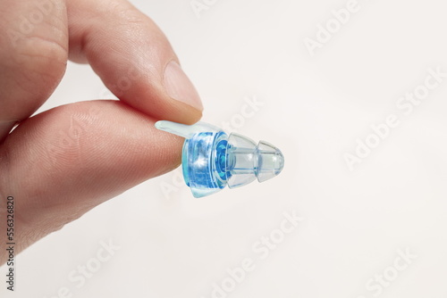 Human silicone earplugs hold fingers on white background