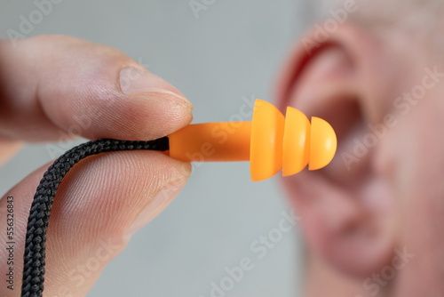 Canvas Print Human silicone earplugs hold fingers on white background