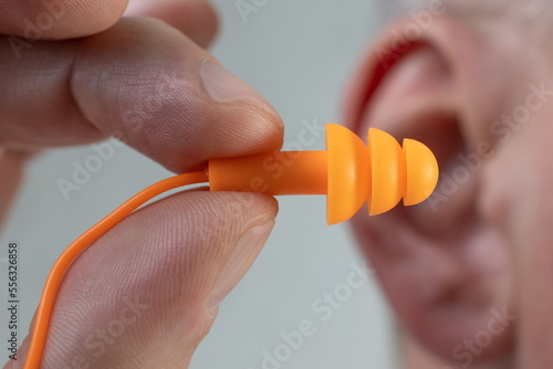 Obraz na płótnie Human silicone earplugs hold fingers on white background