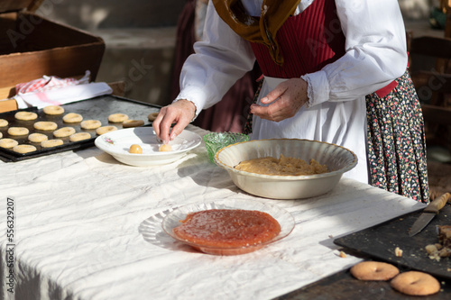 woman preparing dough to make sweet rolls in typical costume