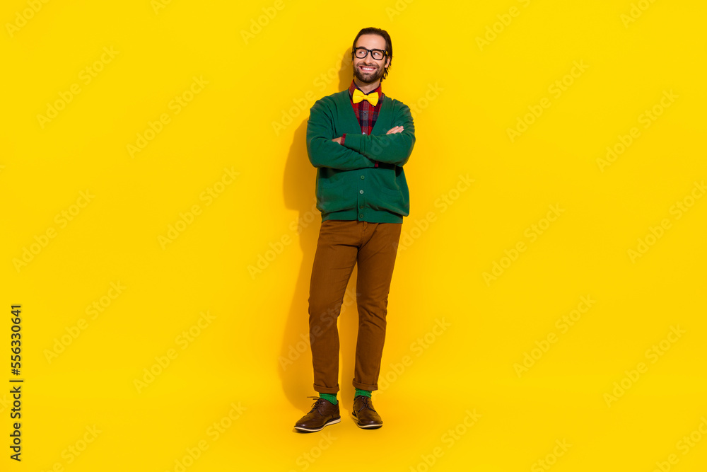 Full body photo of positive successful guy folded arms look empty space isolated on yellow color background Full body photo of positive successful guy folded arms look empty space isolated on yellow color background