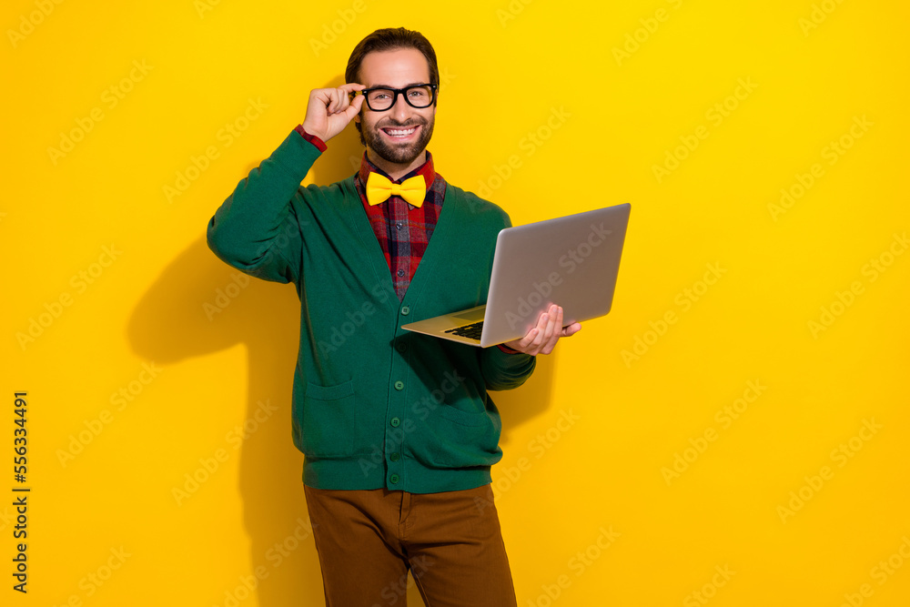 Photo of young brunet hair handsome guy wear green jumper try glasses hold his apple macbook for remote work isolated on yellow color background