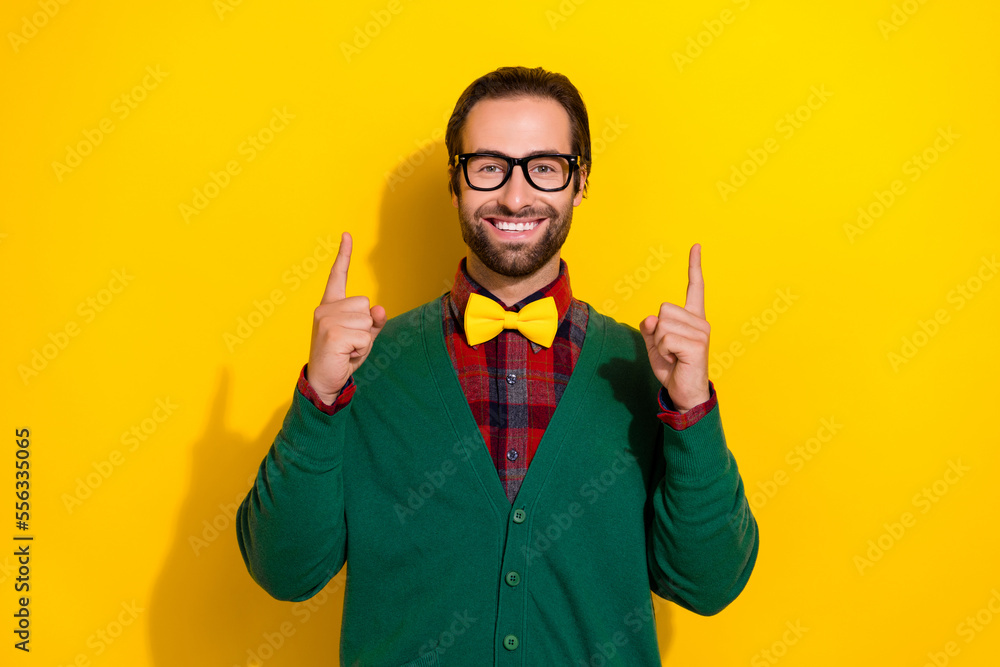 Photo portrait of young attractive male specs point up empty space smile wear trendy green outfit isolated on yellow color background Photo portrait of young attractive male specs point up empty space smile wear trendy green outfit isolated on yellow color background
