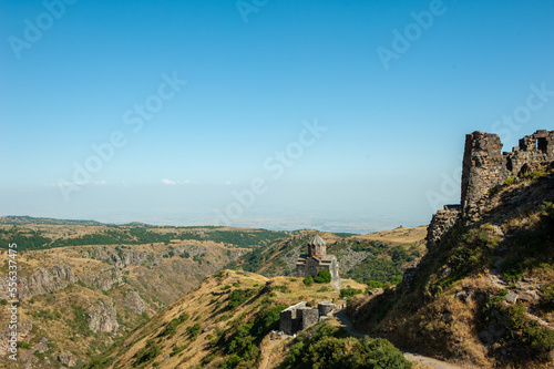 Ancient Christian temple in the mountains and the walls of the ruined fortress. Armenian holy and tourist place. Monument of culture  religion and history