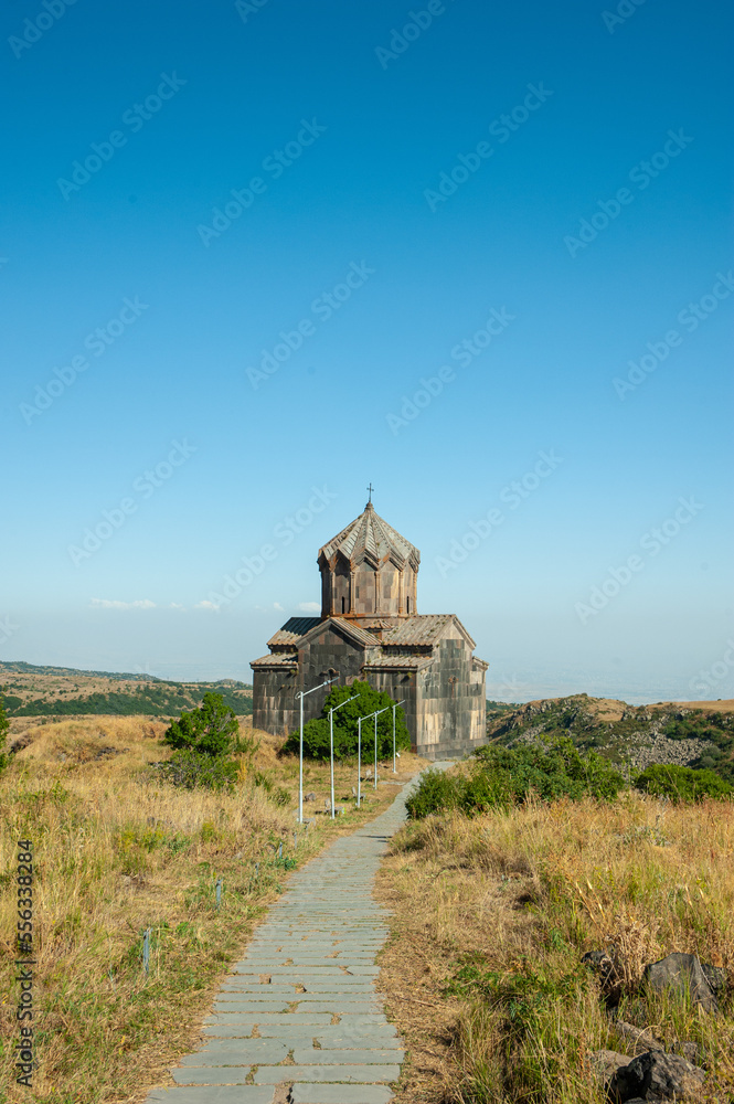 Christian church made of stone tuff in armenia of an ancient building in the mountains against the backdrop of beautiful nature and blue sky. Faith in God and Religion, Tourism and Cultural Heritage
