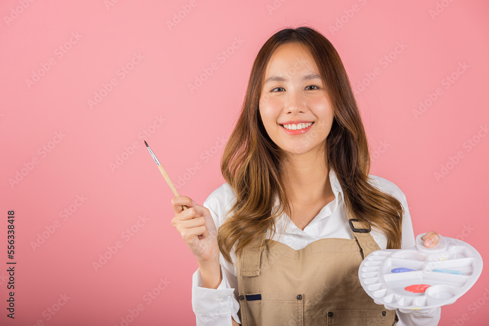 Portrait Asian young woman artist holding brush and paint palette, Happy female painting using paintbrush and palette with colors, studio shot isolated on pink background, Art design workshop Portrait Asian young woman artist holding brush and paint palette, Happy female painting using paintbrush and palette with colors, studio shot isolated on pink background, Art design workshop