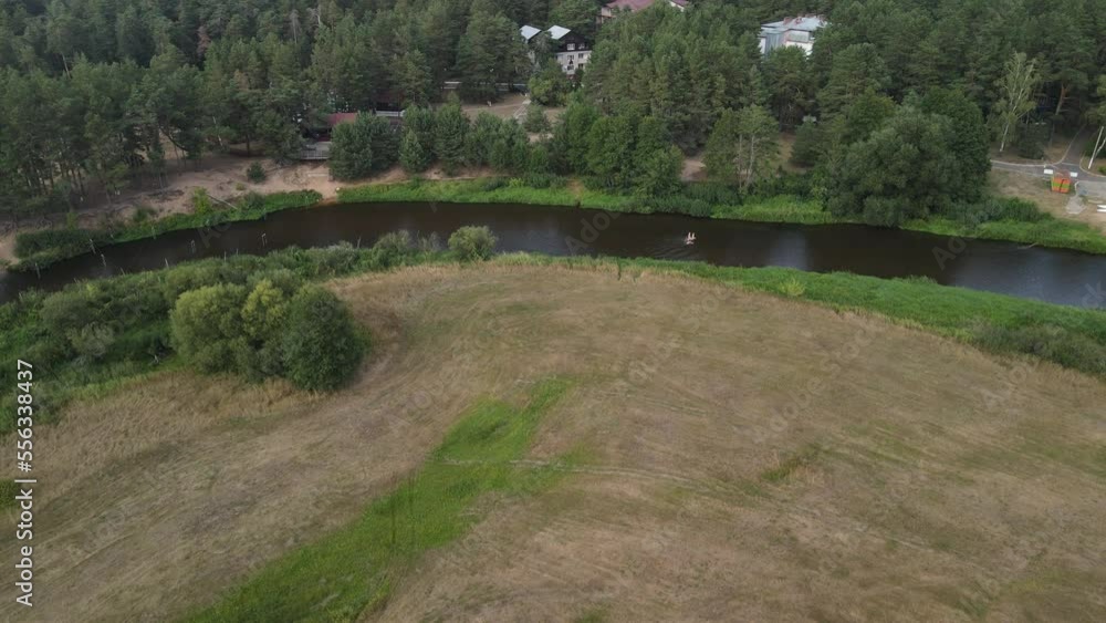 Aerial drone view of the river and green forests and fields on a summer day. Aerial drone view of the river and green forests and fields on a summer day.