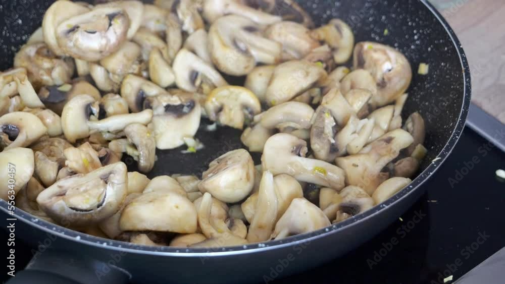 Mixing mushrooms, champignons with a spatula when frying them in a pan at home. Mixing mushrooms, champignons with a spatula when frying them in a pan at home.