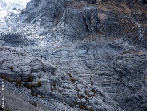 Man on the rocks near al nevado, in the mountains of Peru South America