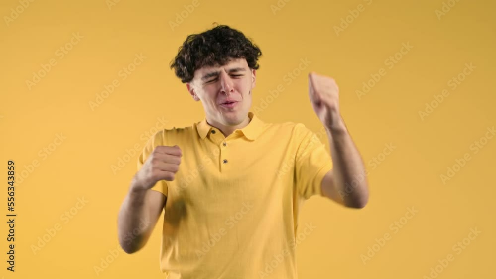 Curly man shows triumph yes YEAH gesture of victory, he achieved result, goals. Guy glad, happy, surprised excited happy lady on yellow background. Jackpot concept. Curly man shows triumph yes YEAH gesture of victory, he achieved result, goals. Guy glad, happy, surprised excited happy lady on yellow background. Jackpot concept.