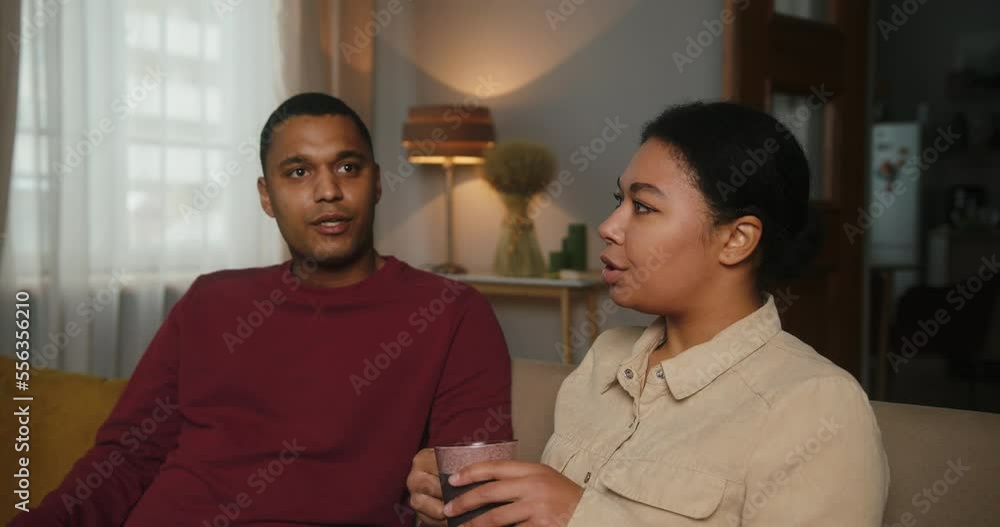 Couple sits on comfy sofa and talks together about life Couple sits on comfy sofa and talks together about life