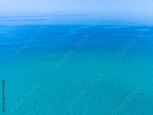 Aerial view of blue sea surface water texture background and sun reflections, Aerial flying drone view, Waves water surface texture on sunny tropical ocean, Top view ocean nature background