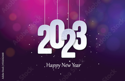 Happy new year 2023. Hanging white paper number with confetti on a colorful blurry background. blur and bokeh design