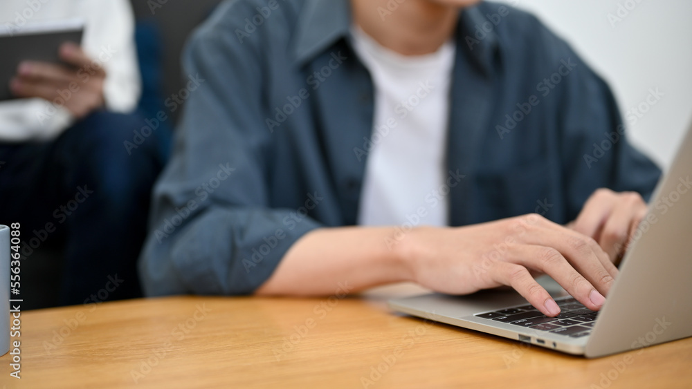 cropped image, A male freelancer or college student using laptop, typing on keyboard cropped image, A male freelancer or college student using laptop, typing on keyboard