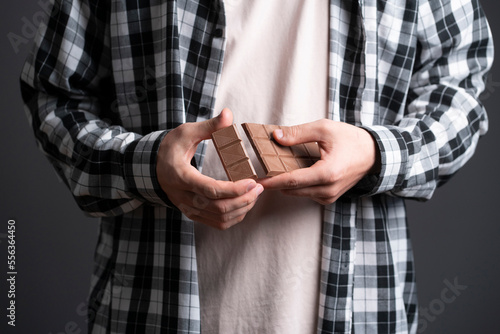 person holding and braking black chocolate bar