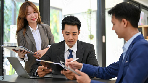 Wallpaper Mural Smart Asian male boss talking and working with his financial employees in the office. Torontodigital.ca