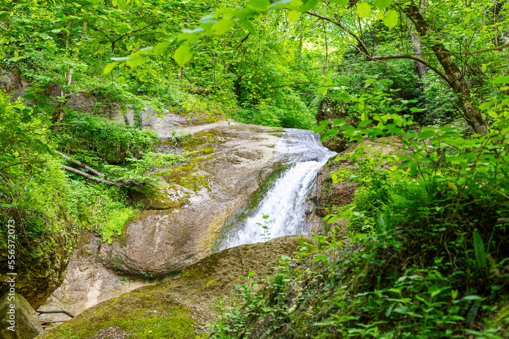 A mountain river in a natural channel with rapids and waterfalls. A mountain river in a natural channel with rapids and waterfalls.