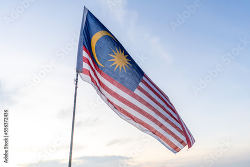Malaysia flag also known as Jalur Gemilang against bright blue sunrise sky. Malaysia Independence Day. photo