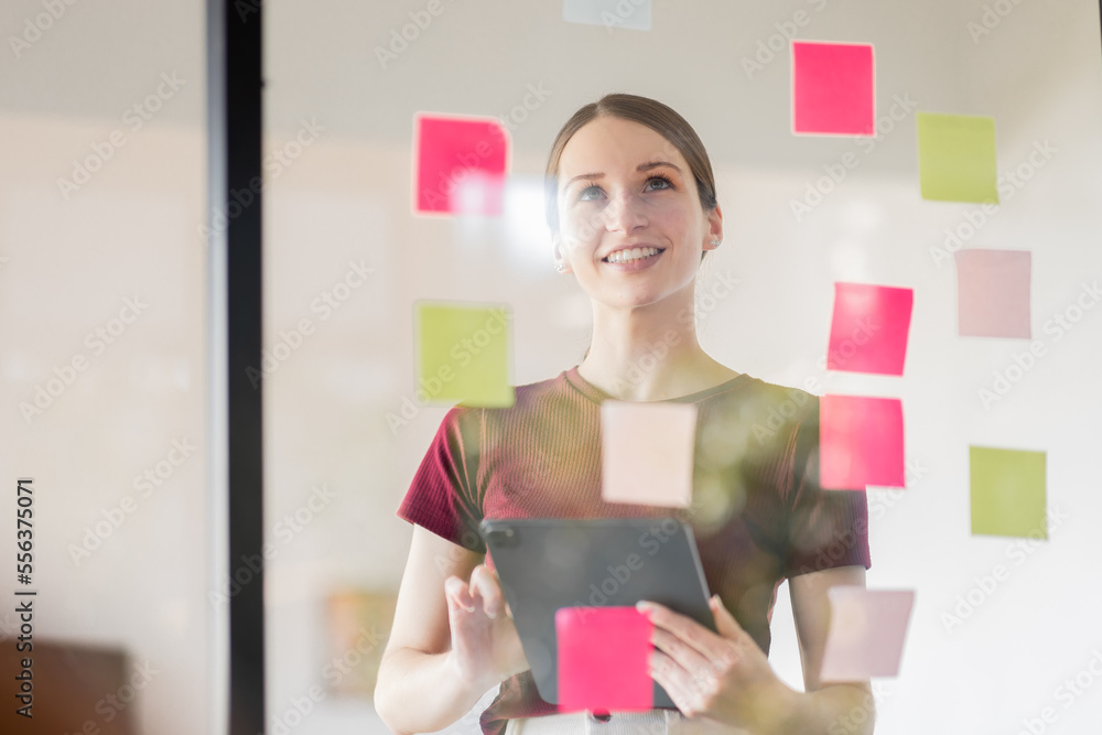 Business woman meeting at office and use post it notes in glass wall to share idea. Brainstorming business office concept. Sticky note on glass wall. Business woman meeting at office and use post it notes in glass wall to share idea. Brainstorming business office concept. Sticky note on glass wall.