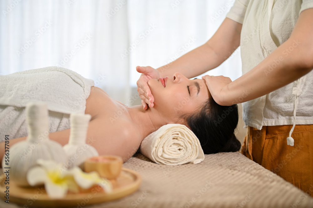 side view, Attractive Asian woman eyes closed, receiving facial massage treatment at spa salon. side view, Attractive Asian woman eyes closed, receiving facial massage treatment at spa salon.