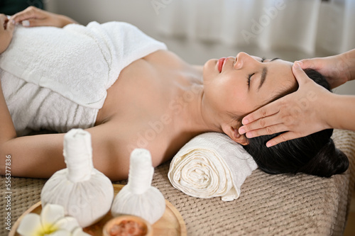 side view, Beautiful and relaxed Asian woman receiving Thai massage, getting massage on her head