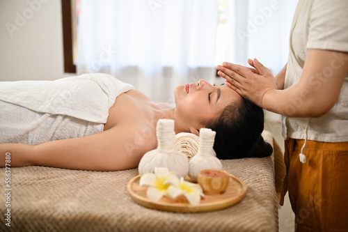 side view, Calm Asian woman lying on massage table, getting massage. Thai spa, Thai massage