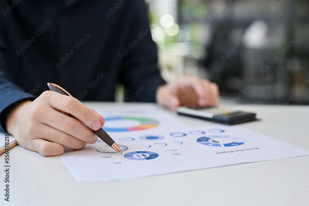 Close up view of young businessman working on his project while analyze the budget Close up view of young businessman working on his project while analyze the budget