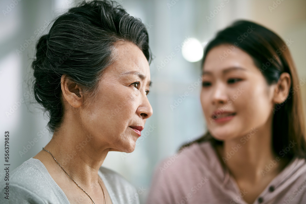 young asian daughter comforting elderly mother young asian daughter comforting elderly mother