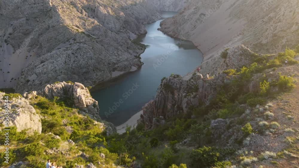 aerial backward view of Zrmanja river at the top of the canyon overlooking the still turquoise water on a sunny day. aerial backward view of Zrmanja river at the top of the canyon overlooking the still turquoise water on a sunny day.