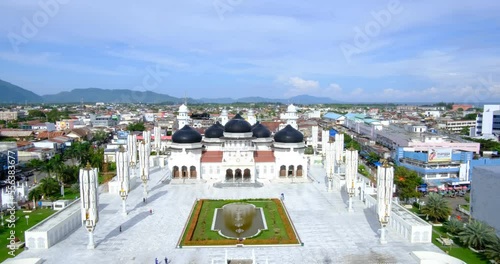 Banda Aceh, Indonesia - December 2022: The atmosphere of the baiturrahman grand mosque during the day with the city of banda aceh photo