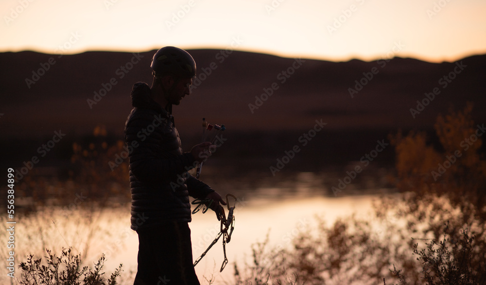 silhouette of a male climber in a helmet against the background of the Ili River in the tamgaly-tas region of Kazakhstan