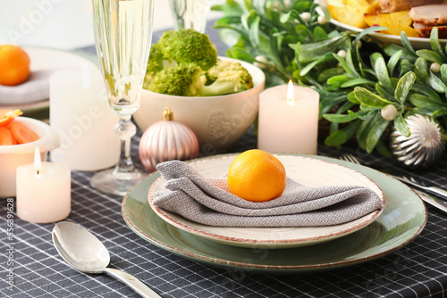 Christmas table setting with mandarin in dining room, closeup