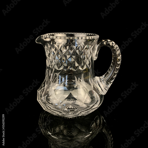 antique glass decanter with geometric pattern. retro decanter for alcohol on a black isolated background. engraved vintage decanter