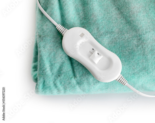 Green electric heating pad with controller on white background, closeup