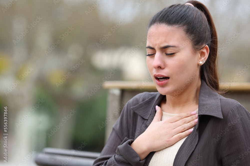 Woman with breathing problems in a park Woman with breathing problems in a park