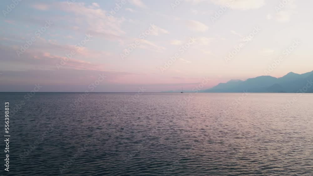 The camera quickly flies into the sea low over the water behind a yacht sailing in the distance at sunset. A beautiful shot of a yacht chasing in the sea at sunset. Aerial view high quality 4k footage The camera quickly flies into the sea low over the water behind a yacht sailing in the distance at sunset. A beautiful shot of a yacht chasing in the sea at sunset. Aerial view high quality 4k footage