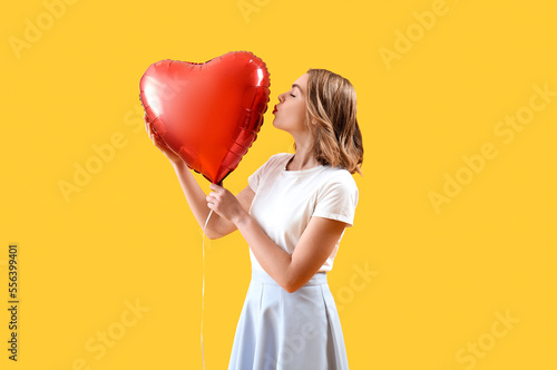 Young woman kissing red hea...