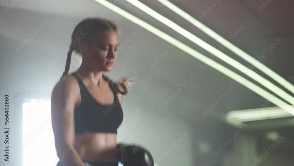 Female fighter warms up and jumps before training in the boxing gym, strength fit body. Female fighter warms up and jumps before training in the boxing gym, strength fit body.