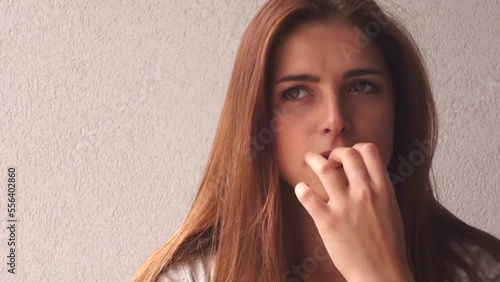 brunette teenager girl biting her nails photo