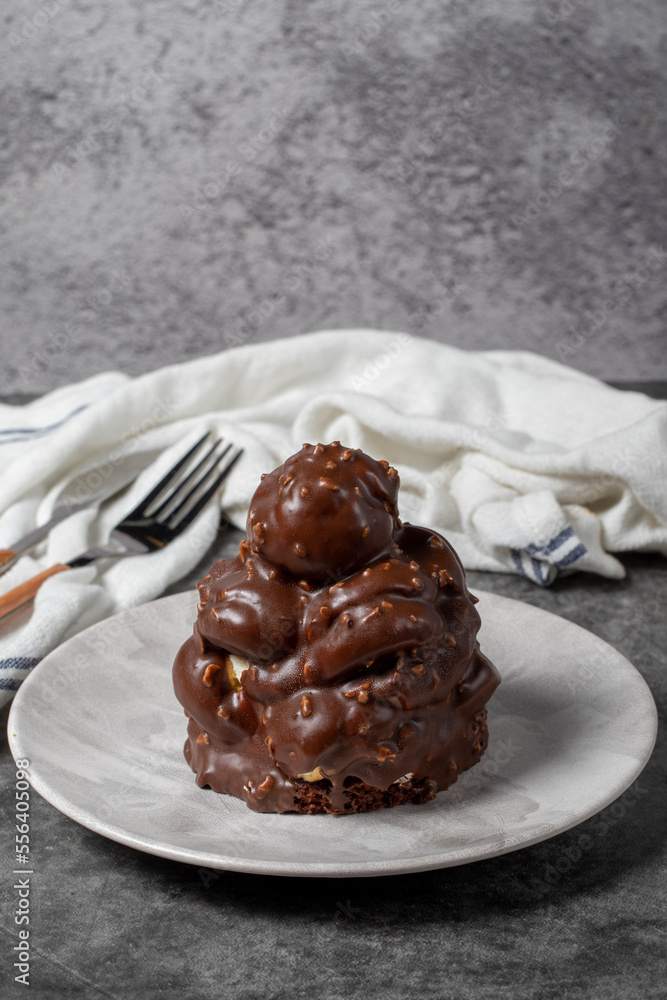Chocolate cake on a dark background. Dessert with chocolate sprinkled on profiteroles grains. Bakery products Chocolate cake on a dark background. Dessert with chocolate sprinkled on profiteroles grains. Bakery products