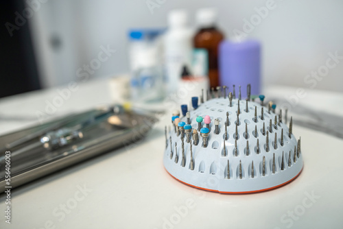 Dental tweezers lie in a metal tray and a bunch of other parts. photo