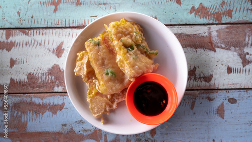 Food photography of traditional Indonesian food called tempe mendoan served on a vintage wooden table photo