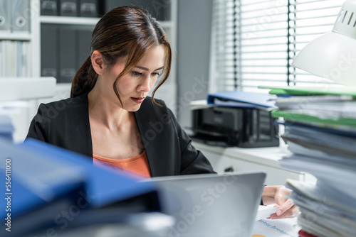 Frustrated Asian young businesswoman overwork late in office at night. 